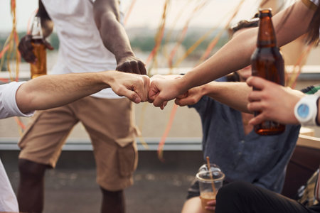 Unity of people. Group of young people in casual clothes have a party at rooftop together at daytimeの写真素材