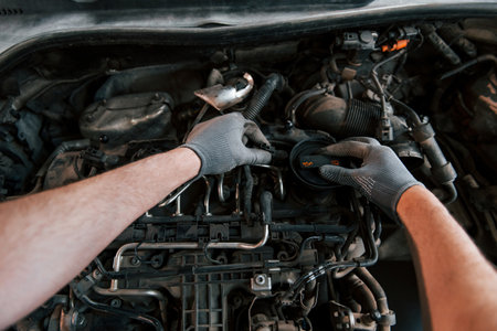 First person view of mans hands that repairs automobile. Conception of automobile serviceの写真素材