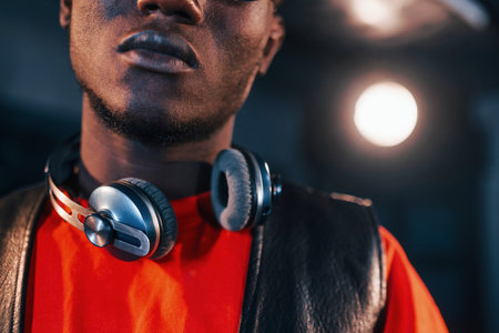 Young african american performer standing in a recording studio and holding headphonesの写真素材