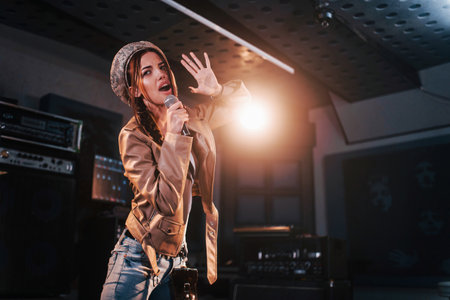 Young beautiful female singer rehearsing in a recording studioの写真素材