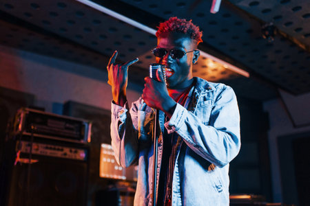 Young african american performer rehearsing in a recording studioの写真素材