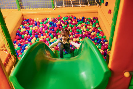 Happy little girl in casual clothes have fun in childrens game complexの写真素材