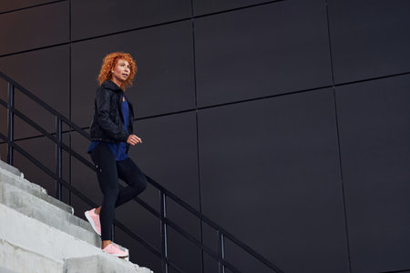 Young european redhead woman have walk on the stairs outdoorsの写真素材