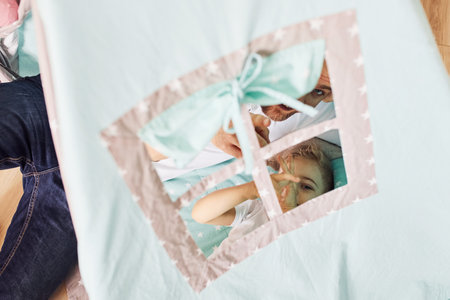 Father and his young young spending time together inside of tentの写真素材