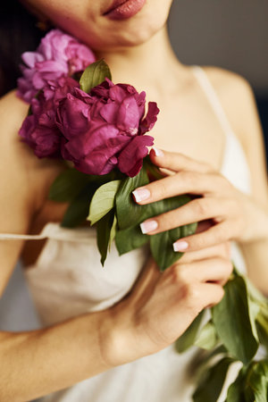 Holding flowers. Young woman resting and spending weekend at home alone at homeの写真素材