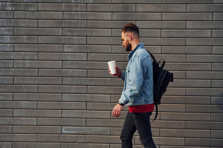 Handsome young guy in casual clothes is outdoors at sunny daytimeの写真素材