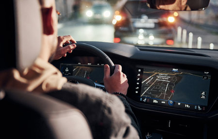 Rear view of handsome unshaved man in fashionable clothes that riding his automobileの写真素材