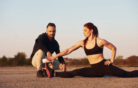 Woman and man have fitness day on the road at evening together