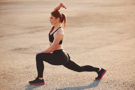 Woman in sportswear have fitness day on the road at evening timeの写真素材