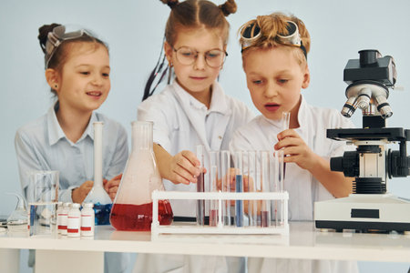 Test tubes with colorful liquid. Children in white coats plays a scientists in lab by using equipmentの写真素材