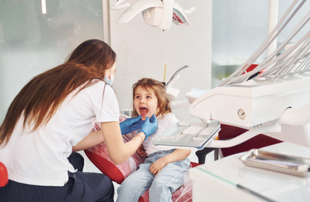 Little girl visiting dentist in clinic. Conception of stomatologyの写真素材