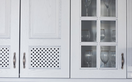 Front view of empty glasses that standing behing glass inside in the kitchenの写真素材