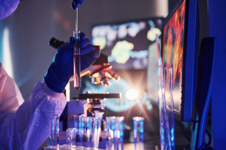 Scientist in white protective uniform works with coronavirus and blood tubes in laboratoryの写真素材