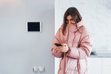 Climate control. Young woman is indoors in smart house room at daytimeの写真素材