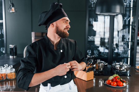 Portrait of professional young chef cook in uniform that posing for camera on the kitchenの写真素材