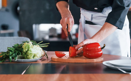 Professional young chef cook in uniform making salad on the kitchenの写真素材
