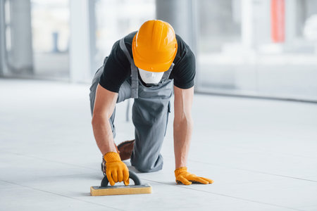 Man in grey uniform works indoors in modern big office at daytimeの写真素材