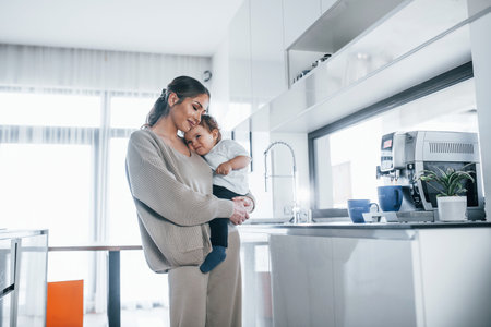 Female blogger mother with her kid together indoors at home at weekendの写真素材