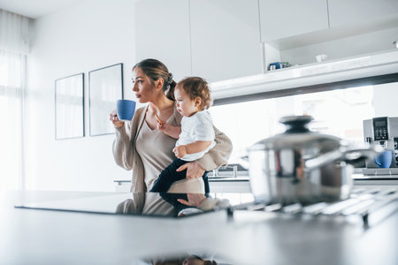 Female blogger mother with her kid together indoors at home at weekendの写真素材