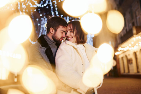Happy young couple celebrating New year outdoors on the street