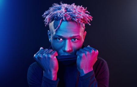 Futuristic neon lighting. Young african american man in the studio