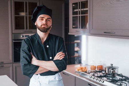 Professional young chef cook in uniform standing on the kitchenの写真素材
