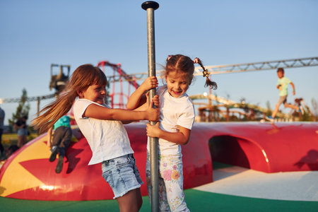 Little girls have fun at childrens amusement park at daytimeの写真素材