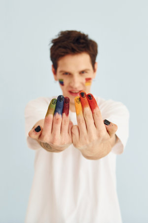 Young gay man is standing in the studio and posing for a camera. Shows gesturesの写真素材
