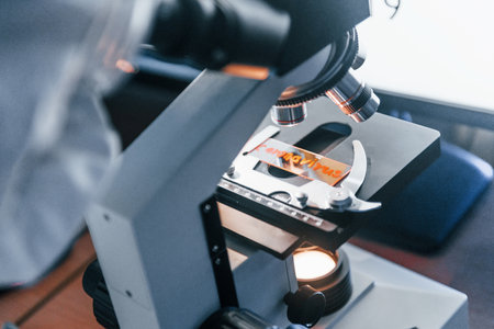 Close up view of scientist in protective uniform that works with coronavirus in laboratoryの写真素材