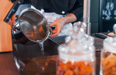 Close up view of professional young chef cook in uniform that working on the kitchenの写真素材