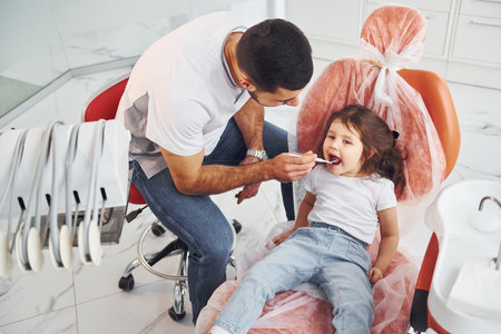 Little girl visiting male dentist in clinic. Conception of stomatologyの写真素材