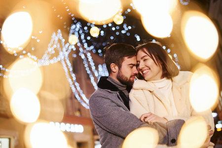 Happy young couple celebrating New year outdoors on the streetの写真素材