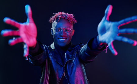 Having fun. Futuristic neon lighting. Young african american man in the studioの写真素材