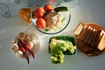 Top view of vegetables that is on the table. Tomatoes, pepper, mushrooms and breadの写真素材