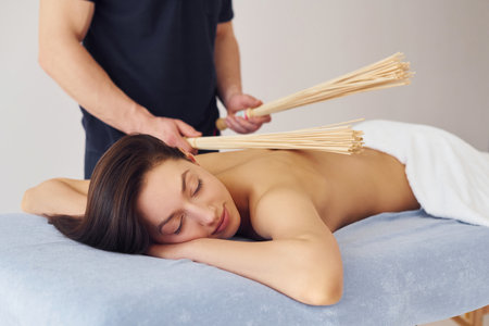 Special equipment. Young woman is lying down when man doing massage of her body at spaの写真素材