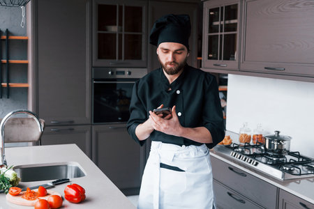 Professional young chef cook in uniform standing on the kitchenの写真素材