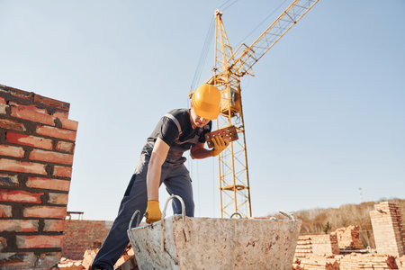 Construction worker in uniform and safety equipment have job on buildingの写真素材