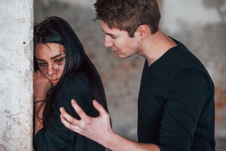 Kidnapped woman is threatened by man in abandoned buildingの写真素材