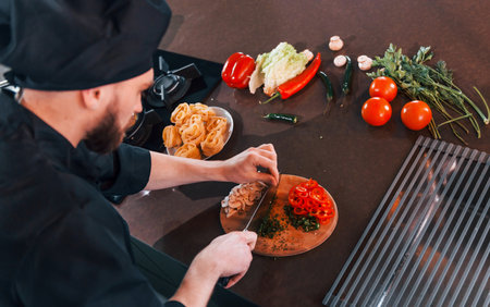 Close up view of professional young chef cook in uniform that working on the kitchenの写真素材