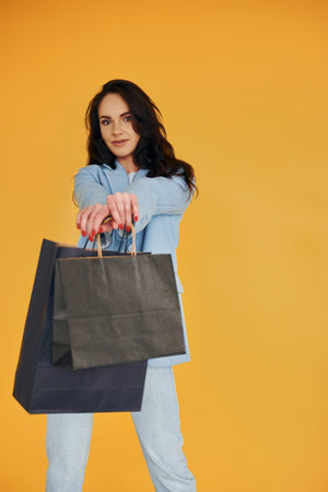 With shopping bags. European woman in fashionable stylish clothes is posing indoorsの写真素材