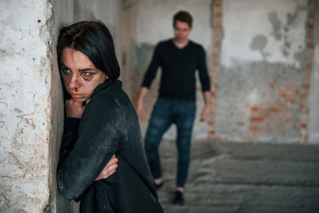Kidnapped woman is threatened by man in abandoned buildingの写真素材