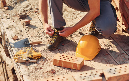 Close up view of construction worker in uniform and safety equipment preparing for the jobの写真素材