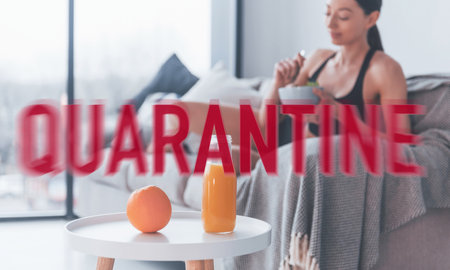 Woman in sportive clothes and fitness body shape sitting at home at quarantine time. Self isolationの写真素材