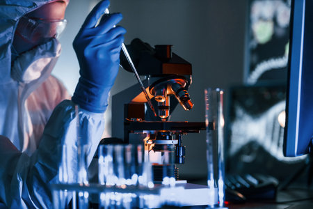 Scientist in white protective uniform works with coronavirus and blood tubes in laboratoryの写真素材