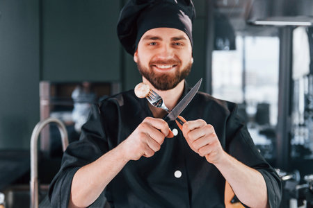 Portrait of professional young chef cook in uniform that posing for camera on the kitchenの写真素材