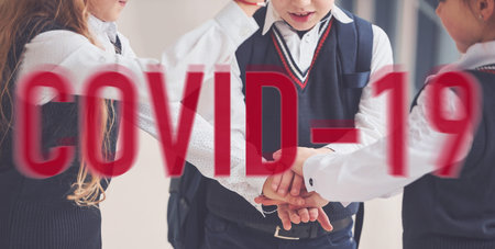 Red quarantine word. Group of kids in school uniform standing together indoors