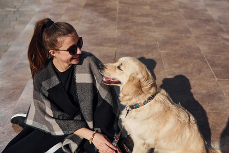 Young positive woman have fun with her dog when have a walk outdoorsの写真素材