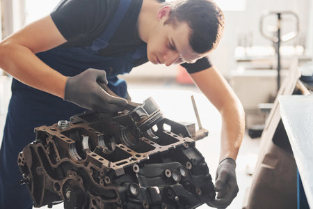 Professional repairman works with broken automobile engineの写真素材