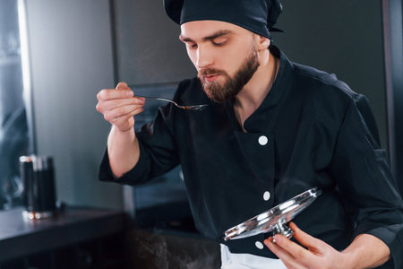Professional young chef cook in uniform working on the kitchen
