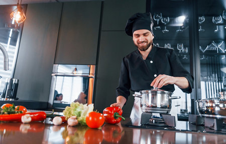 Professional young chef cook in uniform have a busy day on the kitchenの写真素材